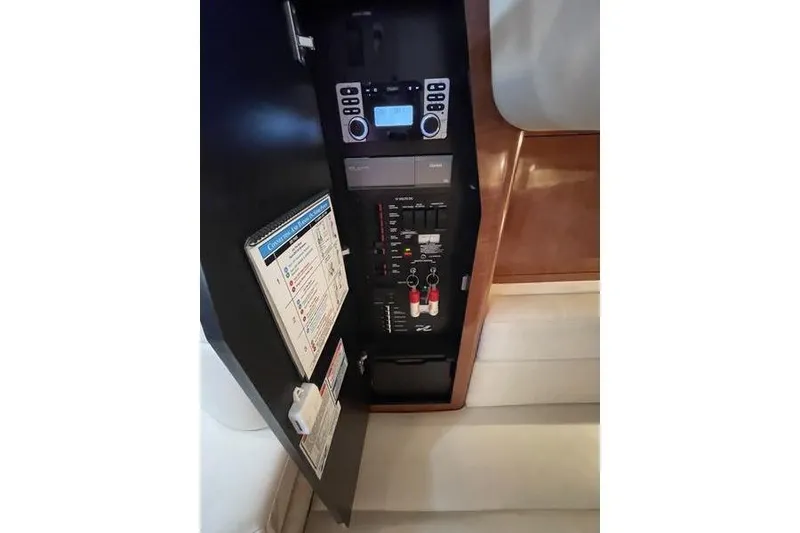 Slide: The Image of Electrical panel of 2003 Sea Ray 320 Sundancer boat, featuring control switches and display. - 13