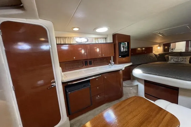 Slide: The Image of Interior of 2003 Sea Ray 320 Sundancer with wood cabinetry and cozy sleeping area. - 6