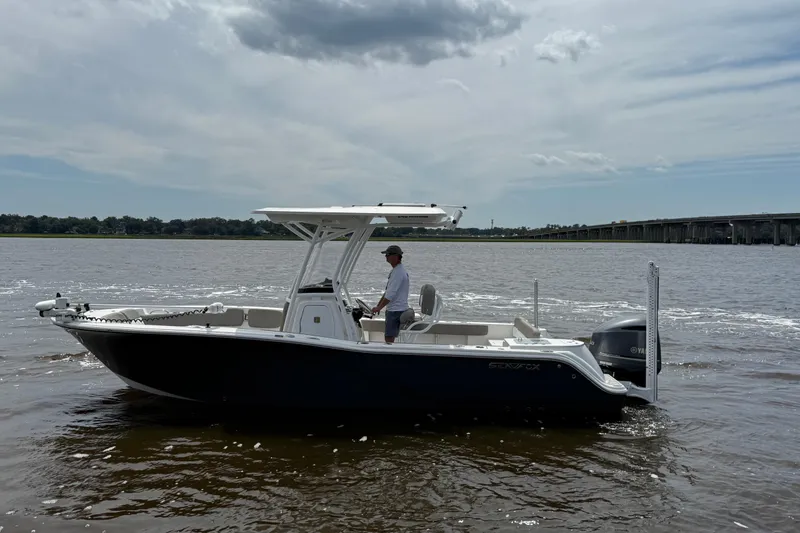 Slide: The Image of 2021 Sea Fox 248 Commander boat cruising on a river under a cloudy sky. - 2