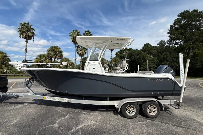 Slide: The Image of 2021 Sea Fox 248 Commander boat on trailer, parked outdoors with palm trees in background. - 6