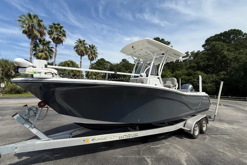 Slide: The Image of 2021 Sea Fox 248 Commander boat on trailer, parked with palm trees in background. - 7