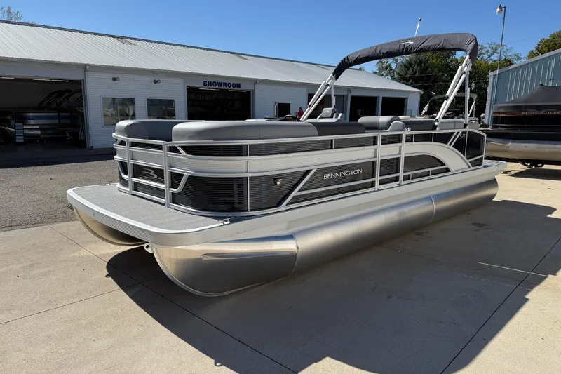 Slide: The Image of 2026 Bennington 22 SLJ pontoon boat with ladder, parked outdoors on a sunny day. - 6