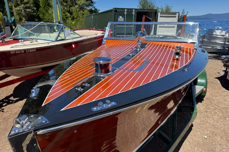 The Image of 1987 Grand Craft Runabout boat with polished wood finish, docked near a lake. - 1