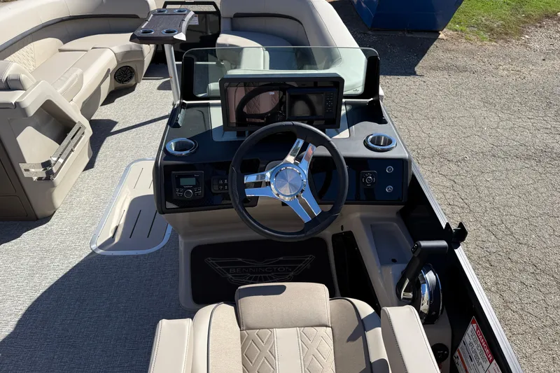 Slide: The Image of 2026 Bennington 24 M Fastback boat interior with steering wheel and seating area. - 16