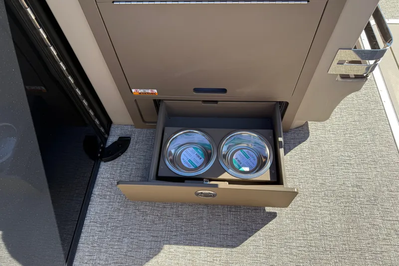 Slide: The Image of Open drawer with pet bowls on a 2026 Bennington 24 M Fastback boat. - 24