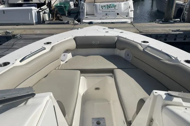 Slide: The Image of 2021 Key West 239 DFS boat interior with cushioned seating at a marina. - 10