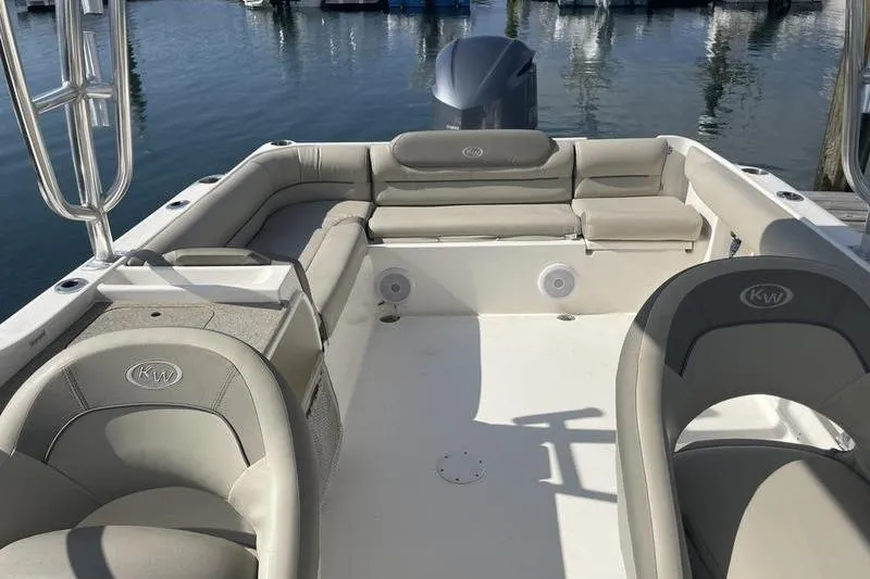 Slide: The Image of 2021 Key West 239 DFS boat interior with beige seating, docked by the water. - 2