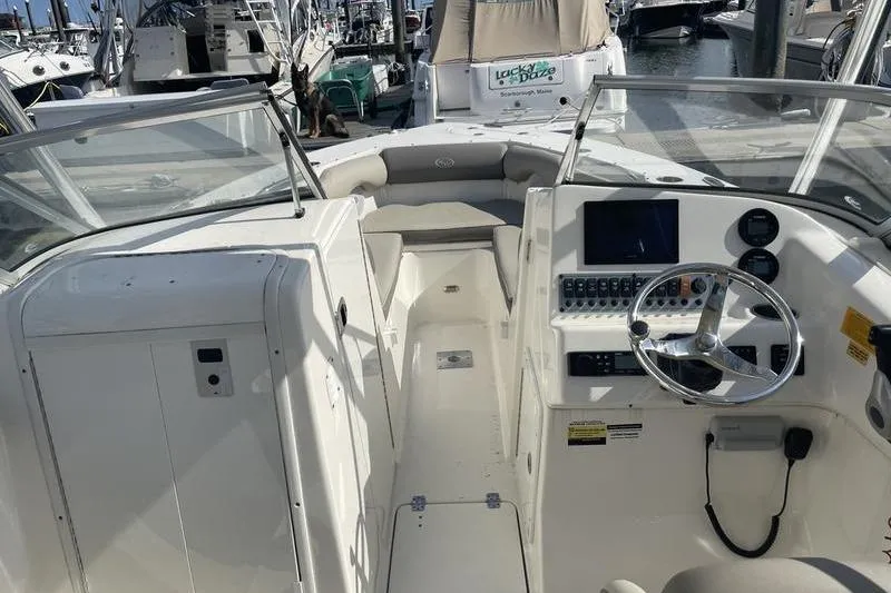 Slide: The Image of 2021 Key West 239 DFS boat interior with steering wheel and dashboard at marina. - 8