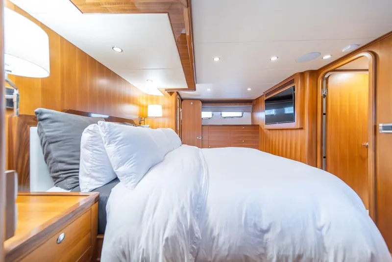 Slide: The Image of Luxurious bedroom interior of 2022 Outer Reef 720 Motor Yacht with wood paneling and cozy bedding. - 48