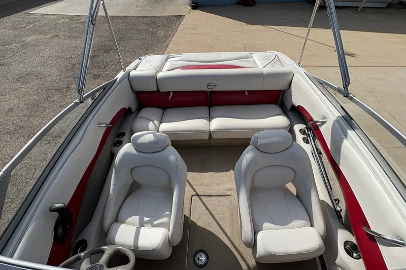 Slide: The Image of 2007 Crownline 190 SS boat interior with white and red seating, steering wheel, and cup holders. - 12
