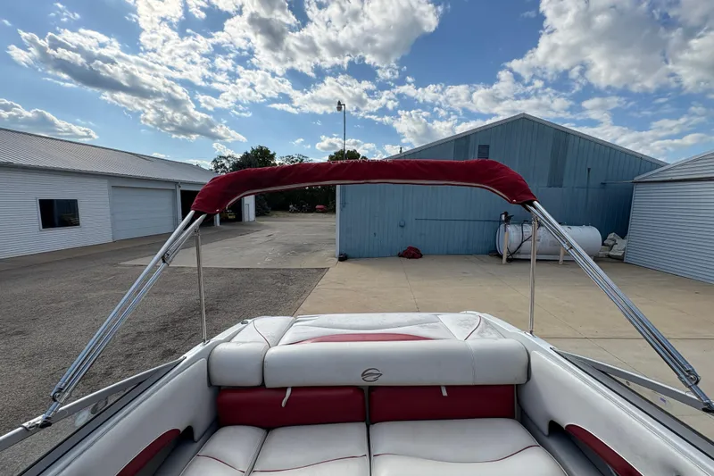 Slide: The Image of 2007 Crownline 190 SS boat interior with red and white seating, docked under a blue sky. - 19