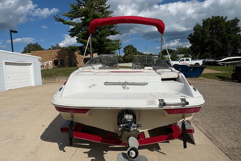 Slide: The Image of 2007 Crownline 190 SS boat with red canopy on trailer, parked outdoors. - 2