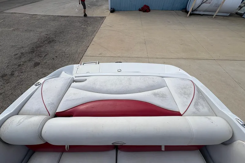 Slide: The Image of 2007 Crownline 190 SS boat interior with red and white seating, docked on concrete. - 21
