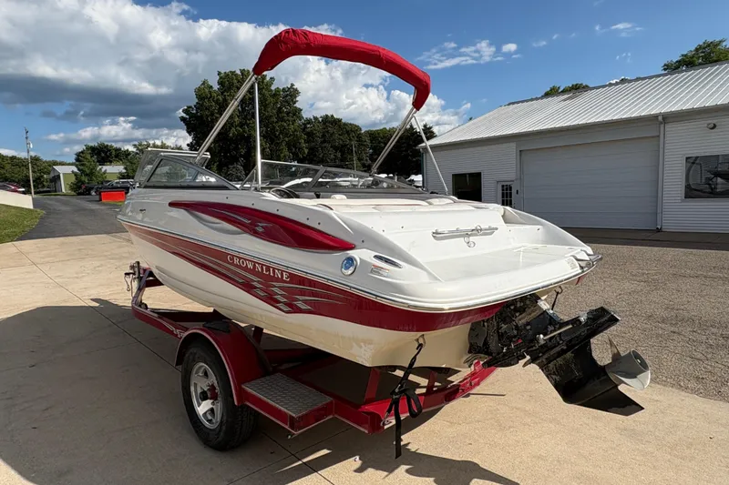 Slide: The Image of 2007 Crownline 190 SS boat with red accents on a trailer, parked outdoors. - 3