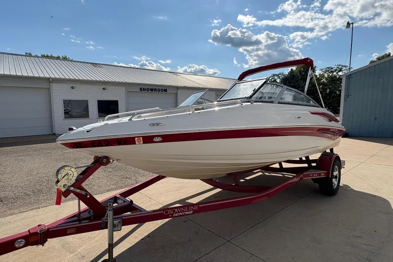 Slide: The Image of 2007 Crownline 190 SS boat on trailer outside showroom under blue sky. - 5