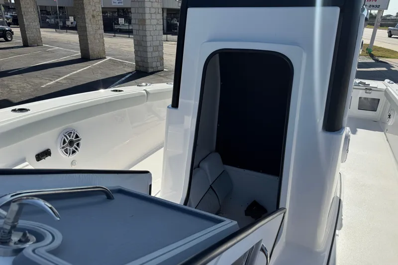 Slide: The Image of 2026 Blackfin 242HB boat interior with seating and sink, docked outdoors. - 19