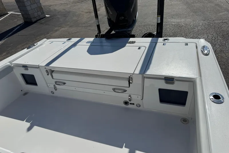 Slide: The Image of 2026 Blackfin 242HB boat deck with storage compartments and motor, in a parking area. - 38