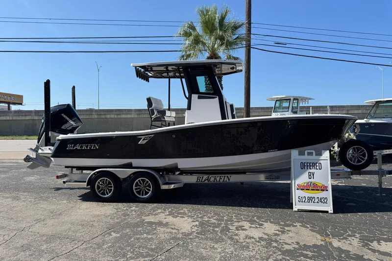 Slide: The Image of 2026 Blackfin 242HB boat on trailer, displayed outdoors with palm tree background. - 49