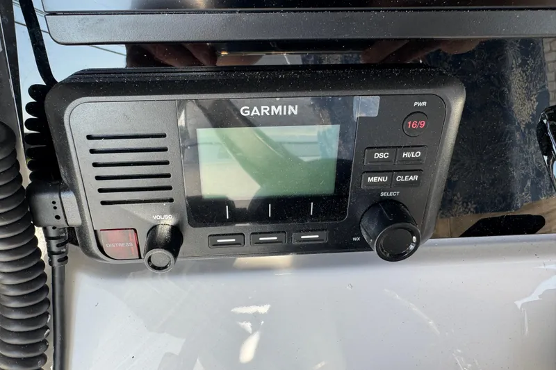 Slide: The Image of Garmin marine radio on 2026 Blackfin 242HB boat dashboard, featuring distress button and controls. - 9