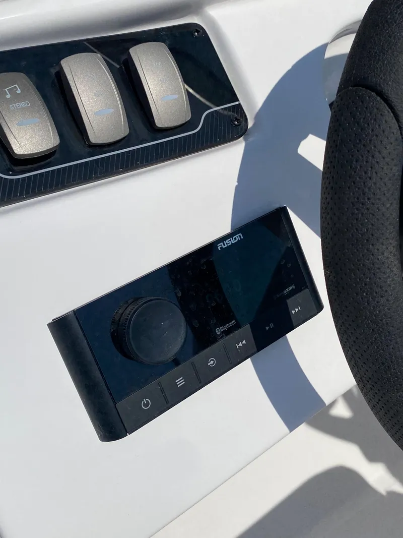 Slide: The Image of 2023 Hurricane SD 2690 OB boat dashboard with Fusion audio controls and steering wheel. - 25