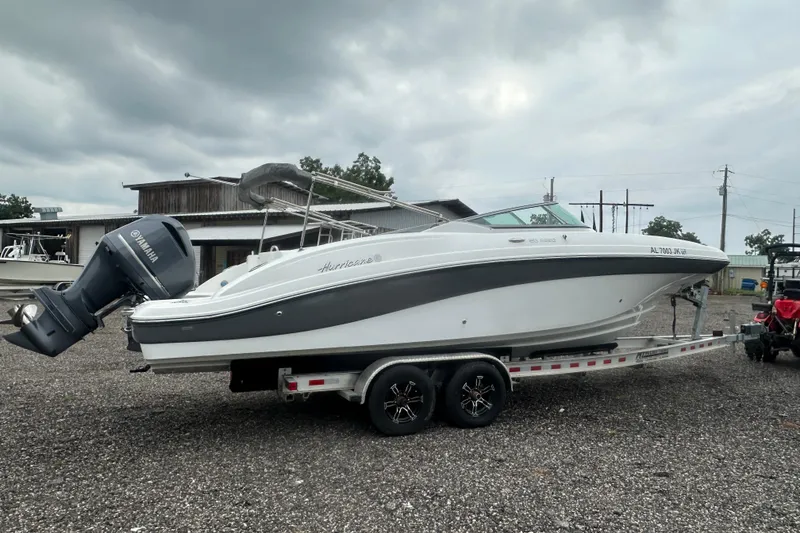 Slide: The Image of 2023 Hurricane SD 2690 OB boat on trailer, parked outdoors under cloudy sky. - 30