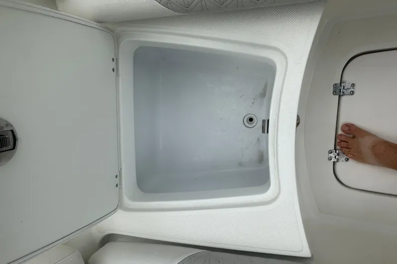 Slide: The Image of Open storage compartment on 2023 Hurricane SD 2690 OB boat, with visible foot. - 41