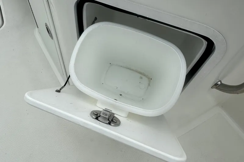 Slide: The Image of 2023 Hurricane SD 2690 OB boat storage compartment with open hatch and white container. - 59