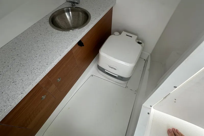 Slide: The Image of 2023 Hurricane SD 2690 OB boat bathroom with sink and portable toilet. - 65
