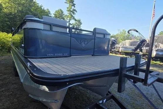 Slide: The Image of 2023 Avalon 2380 Venture Cruise pontoon boat on trailer, surrounded by greenery. - 7