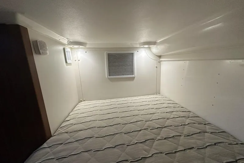 Slide: The Image of 2020 Pursuit OS 355 Offshore cabin interior with wood paneling and bed. - 27