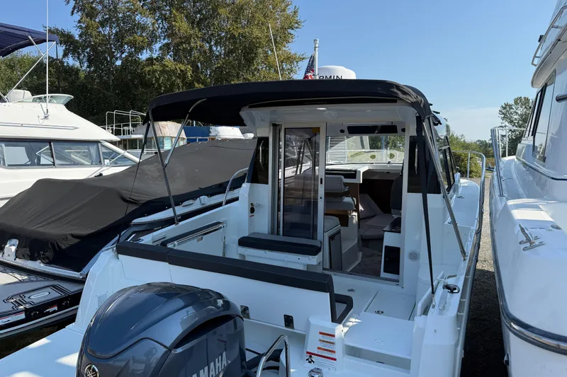 Slide: The Image of 2024 Jeanneau NC Weekender 795 Series 2 boat with Yamaha engine, docked outdoors. - 2