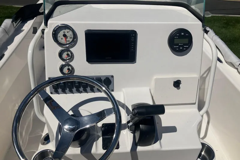 Slide: The Image of 2026 Sundance DX22 boat dashboard with steering wheel and control panel. - 5