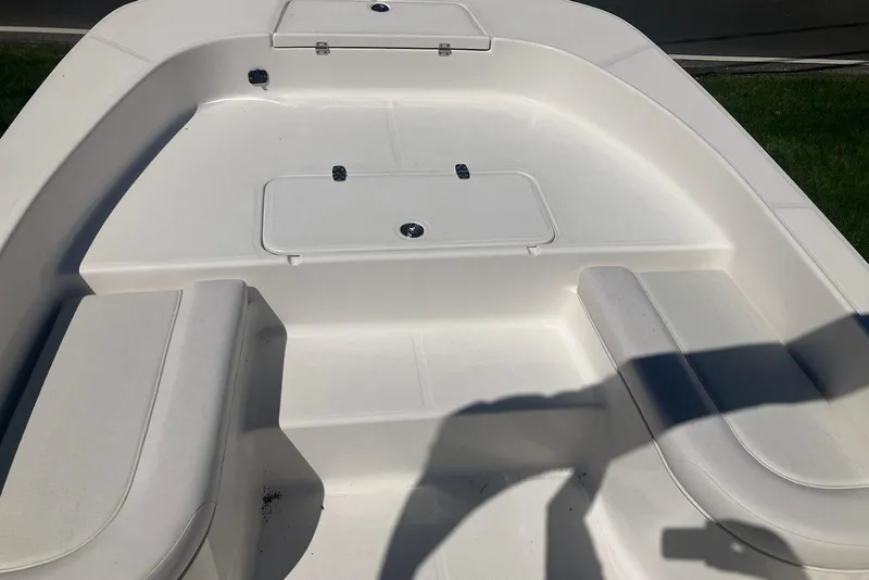 Slide: The Image of 2026 Sundance DX22 boat interior with white seating and storage compartments. - 6