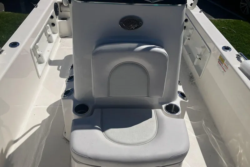 Slide: The Image of Interior of 2026 Sundance DX22 boat with cushioned seating and cup holders. - 7