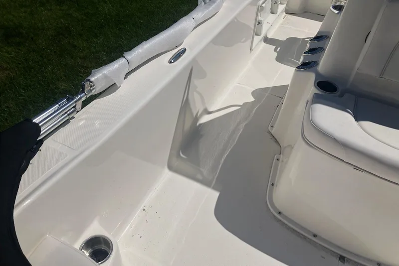 Slide: The Image of Interior of a 2026 Sundance DX22 boat, featuring seating and rod holders. - 8