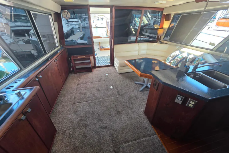 Slide: The Image of 1985 Bayliner 4550 Motoryacht interior with kitchen, seating area, and large windows. - 1