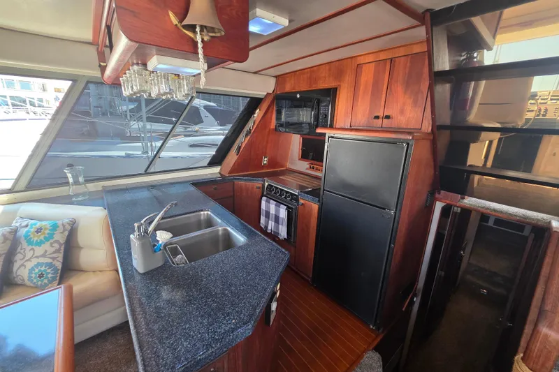 Slide: The Image of Interior of 1985 Bayliner 4550 Motoryacht with kitchen, sink, and wooden cabinetry. - 10