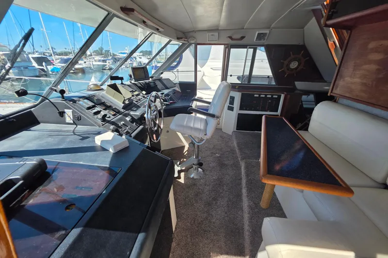 Slide: The Image of Interior of 1985 Bayliner 4550 Motoryacht with helm, seating, and marina view. - 16