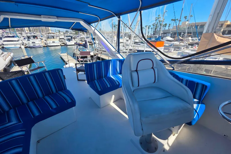 Slide: The Image of 1985 Bayliner 4550 Motoryacht interior with blue seating, marina view, and helm chair. - 19