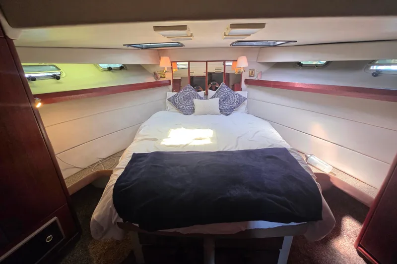 Slide: The Image of Luxurious bedroom interior of 1985 Bayliner 4550 Motoryacht with cozy bedding and ambient lighting. - 28