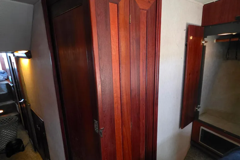 Slide: The Image of Interior of 1985 Bayliner 4550 Motoryacht with wooden cabinetry and open closet. - 30