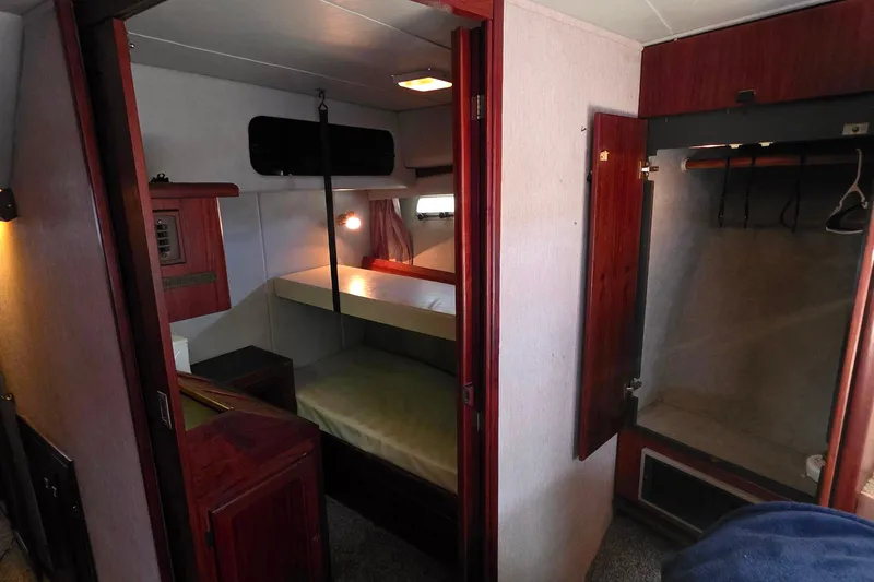 Slide: The Image of 1985 Bayliner 4550 Motoryacht cabin interior with bed, closet, and wooden accents. - 36