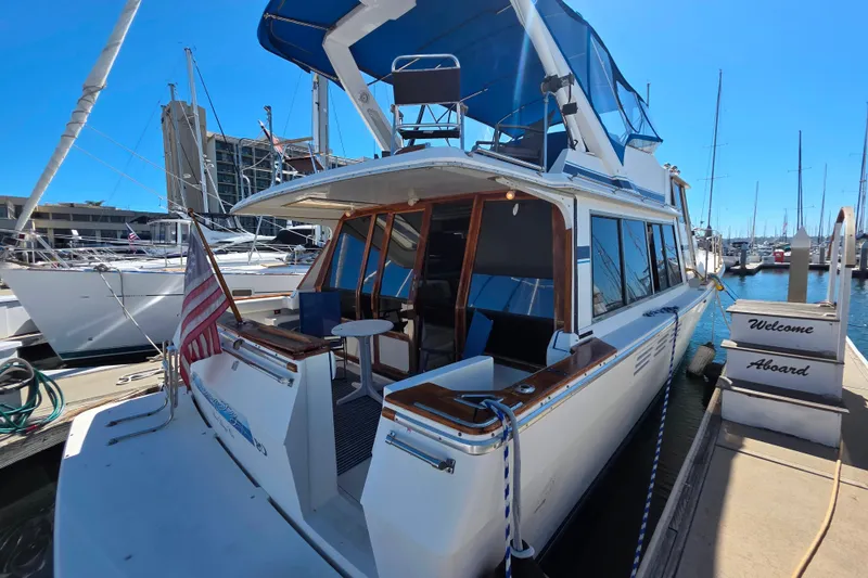Slide: The Image of 1985 Bayliner 4550 Motoryacht docked at marina with American flag and "Welcome Aboard" sign. - 4