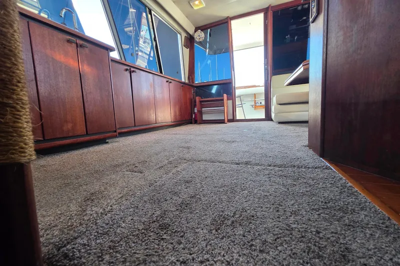 Slide: The Image of Interior of 1985 Bayliner 4550 Motoryacht with carpeted floor and wooden cabinetry. - 49