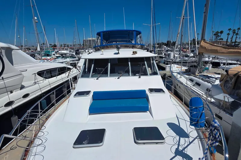 Slide: The Image of 1985 Bayliner 4550 Motoryacht docked in a marina, surrounded by sailboats. - 51