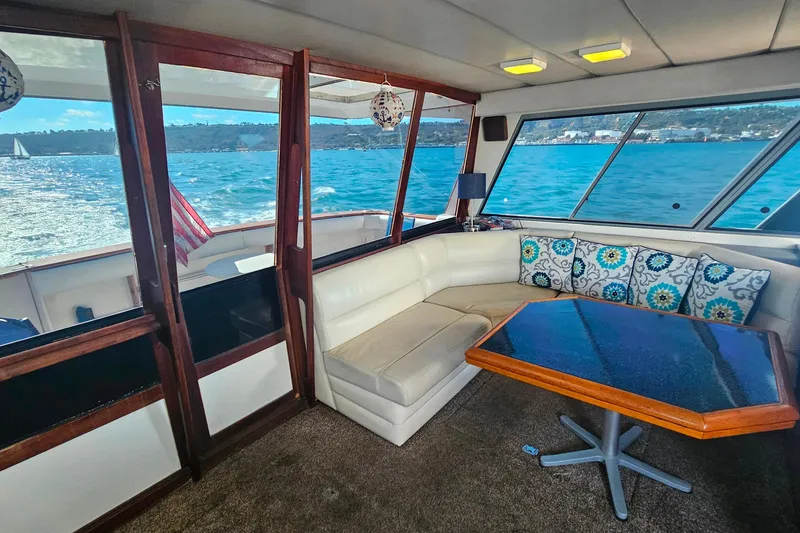 Slide: The Image of 1985 Bayliner 4550 Motoryacht interior with ocean view, cozy seating, and decorative pillows. - 58