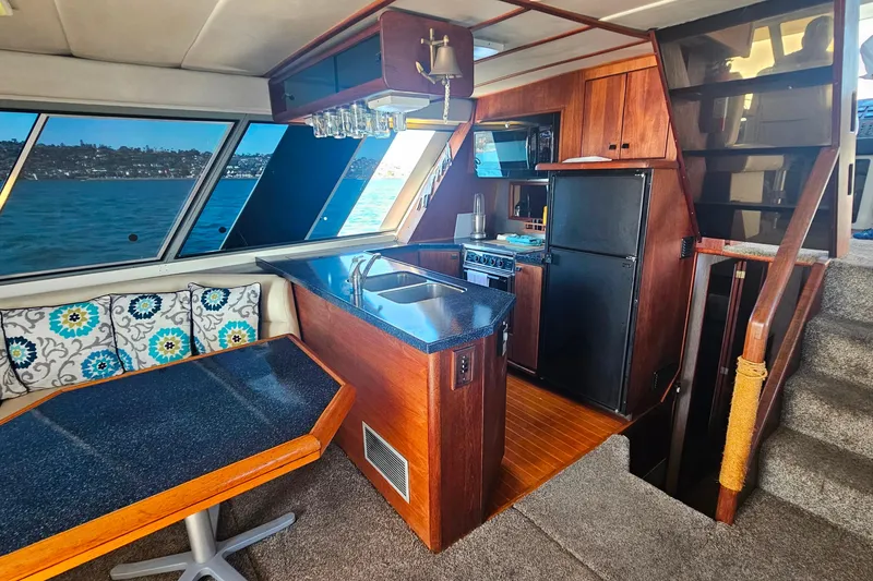 Slide: The Image of Interior of 1985 Bayliner 4550 Motoryacht with kitchen, dining area, and scenic window views. - 61