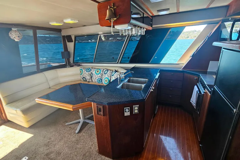 Slide: The Image of Interior of 1985 Bayliner 4550 Motoryacht with kitchen and seating area, overlooking water. - 62