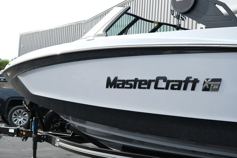 Slide: The Image of 2026 MasterCraft XT24 boat on trailer, side view with logo visible. - 12