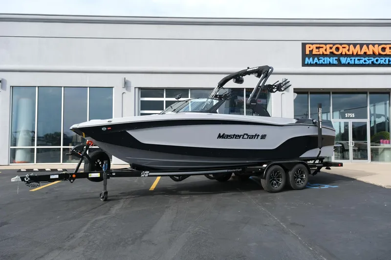 Slide: The Image of 2026 MasterCraft XT24 boat on trailer outside marine dealership. - 2